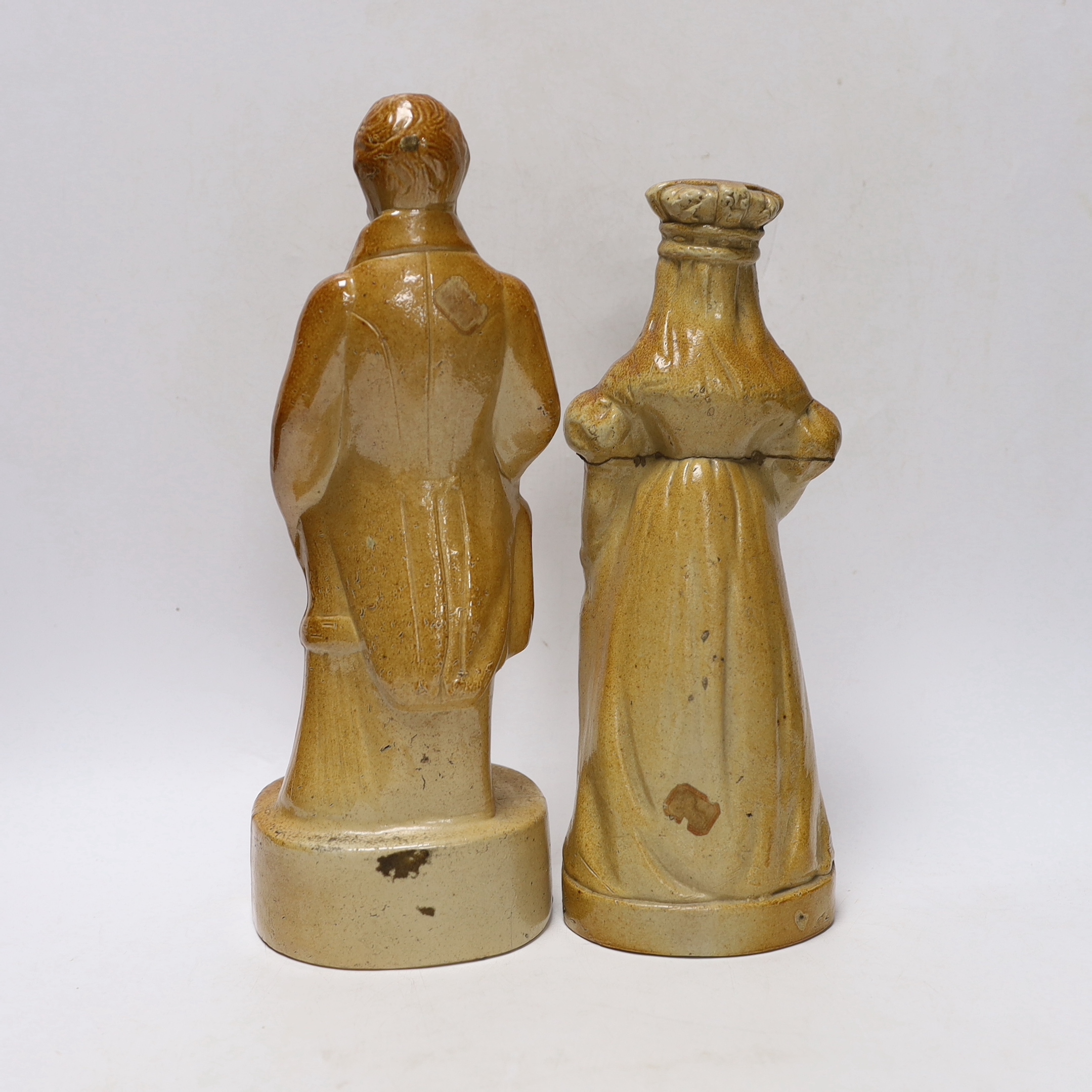 Two Victorian salt glaze spirit flasks, probably Lambeth, the first commemorating the repeal of the Corn Laws in 1846, modelled as Sir Robert Peel and the second modelled as Queen Victoria holding a scroll, impressed 